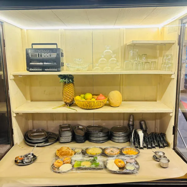 Wooden display cabinet with fresh fruit, steel plates and a breakfast platter