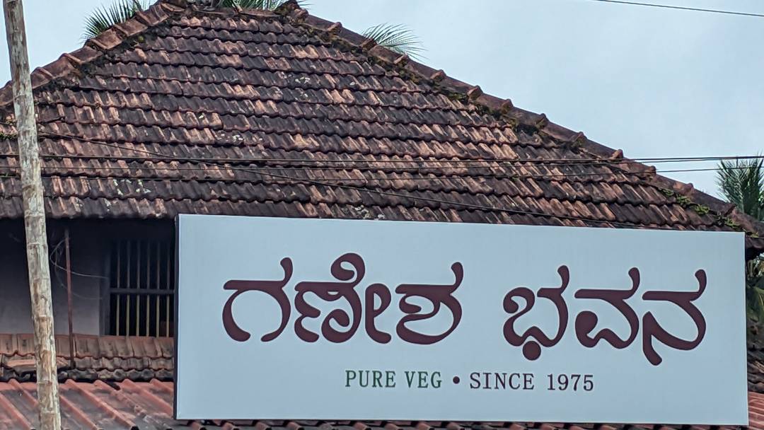 The Ganesh Bhavan signboard in Kannada, Pure Veg Since 1975, under a traditional Mangalore tiled roof